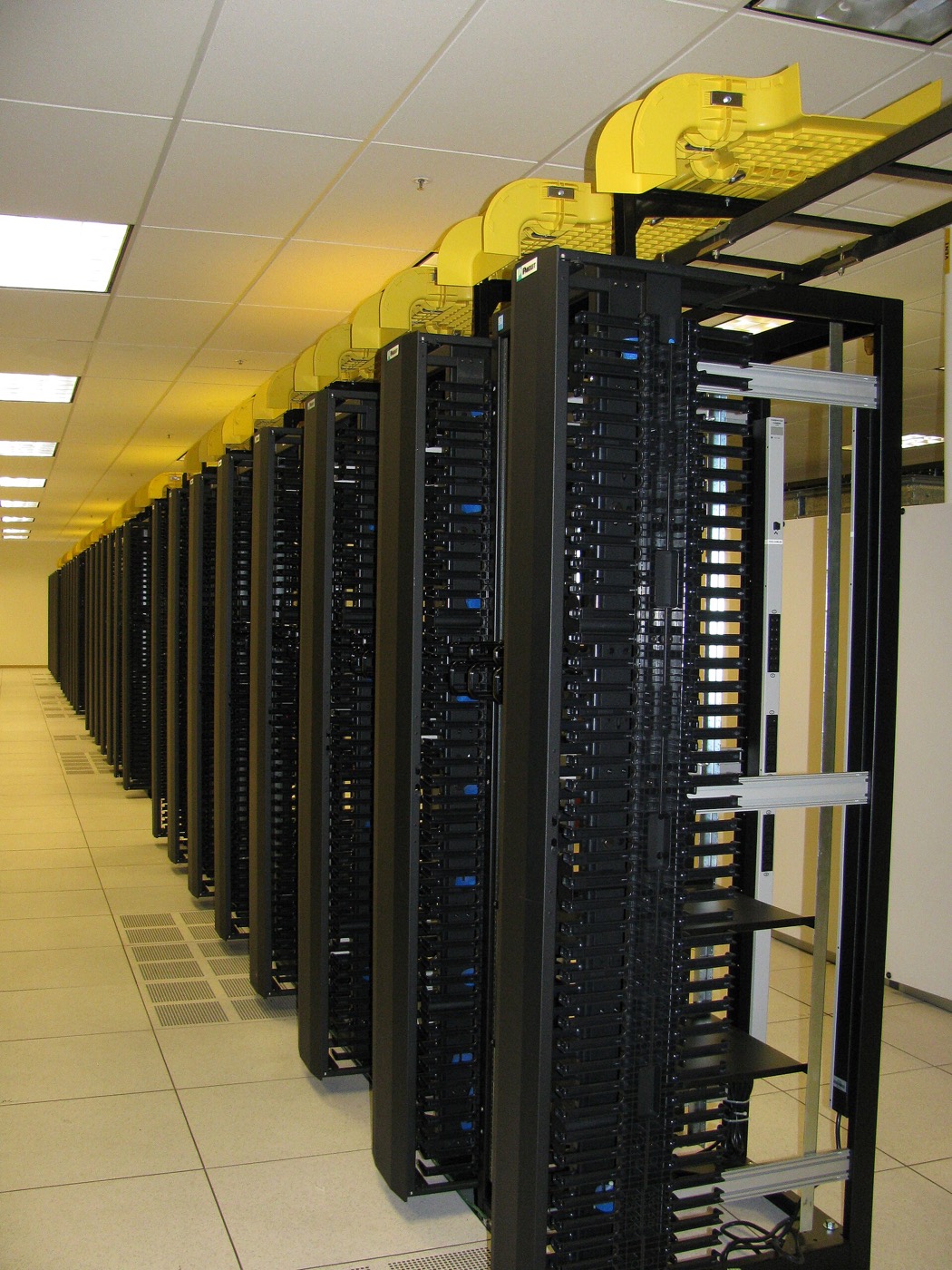Rows of black server racks along a data centre aisle